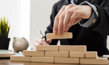 front-view-businessman-with-wooden-building-blocks